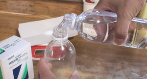 もう一つのペットボトルに水を半分移す